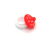 Dies ist ein leuchtend rot-weißes Gefäß in Form eines Fliegenpilzes, das zur Aufbewahrung von einem CBD-Produkt von "kleine knospe" in der Cannabis-Industrie genutzt wird.